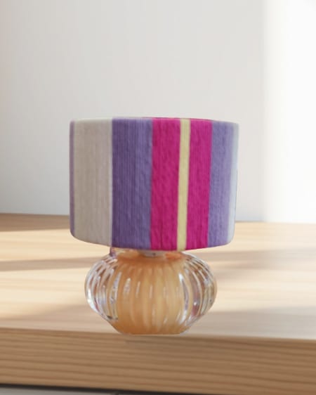A small purple and magenta shade on a ribbed glass base