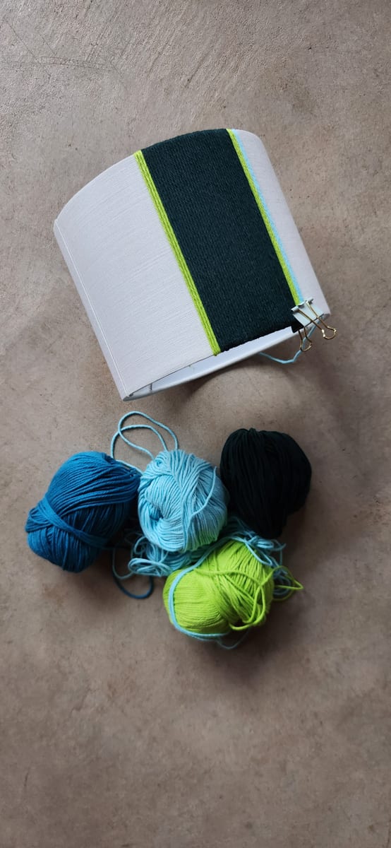 A shade half wrapped in dark green and lime, held with clips