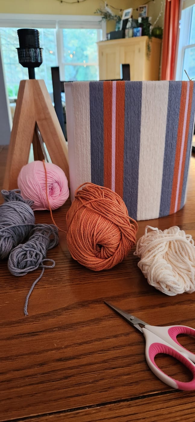 A part-wrapped shade on a kitchen table with yarn and scissors