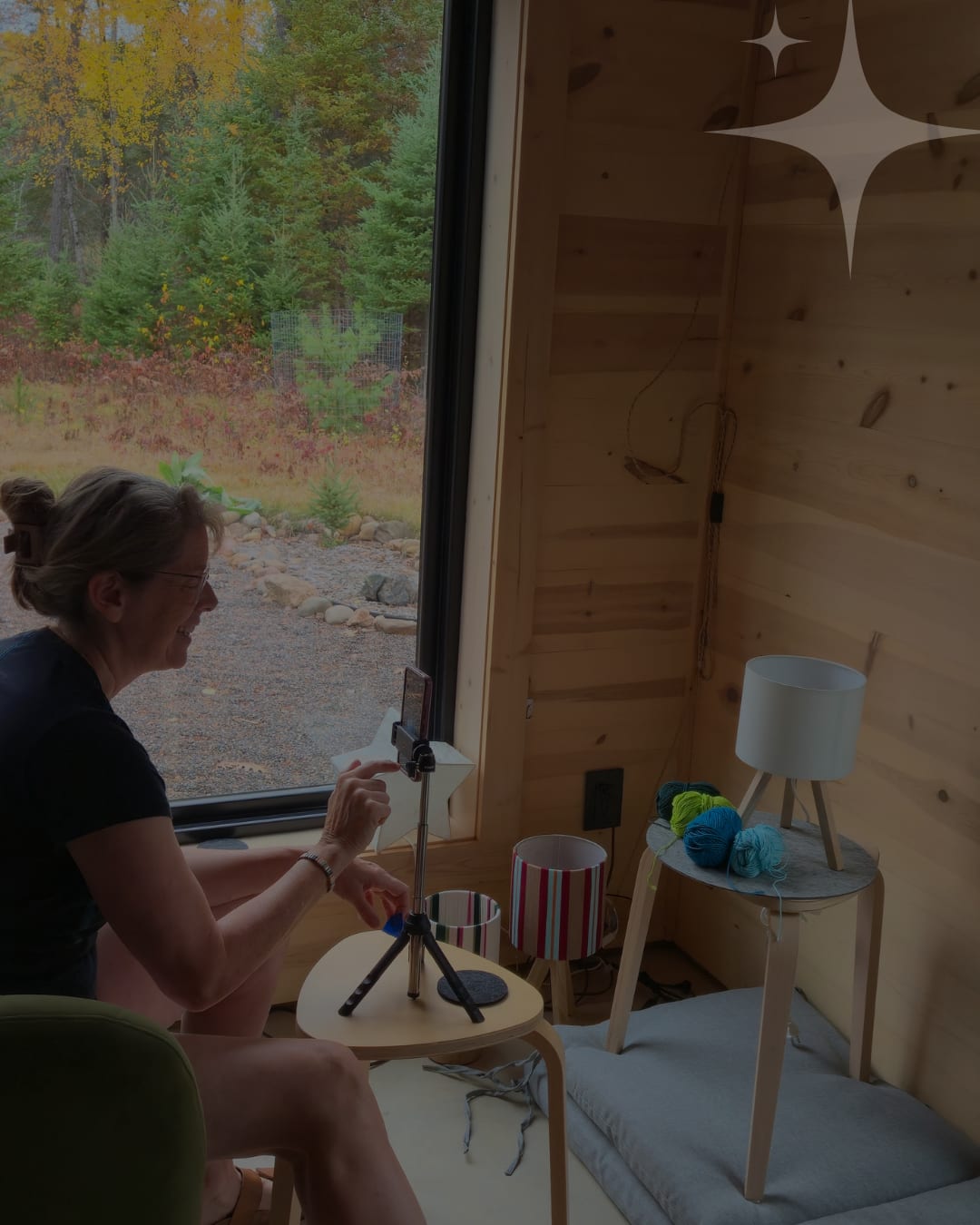 Filming a lampshade demonstration beside a window in a timber cabin